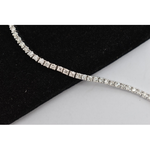 150 - A 9CT WHITE GOLD DIAMOND LINE BRACELET, designed as sixty-four round brilliant cut diamonds each wit... 