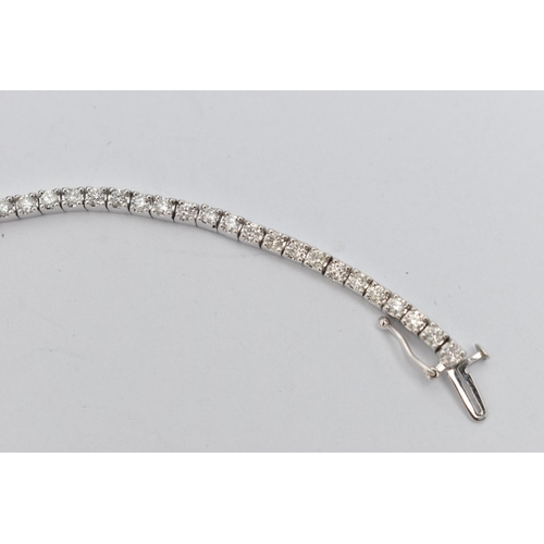 150 - A 9CT WHITE GOLD DIAMOND LINE BRACELET, designed as sixty-four round brilliant cut diamonds each wit... 