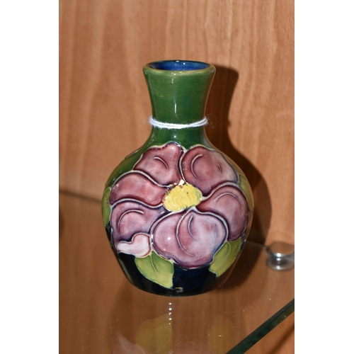 335 - A MOORCROFT POTTERY BUD VASE, in 'Clematis' pattern on a green-blue ground, impressed marks to base,... 