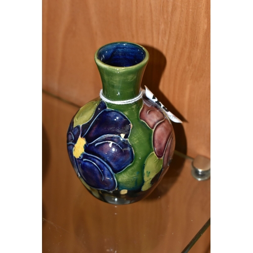 335 - A MOORCROFT POTTERY BUD VASE, in 'Clematis' pattern on a green-blue ground, impressed marks to base,... 