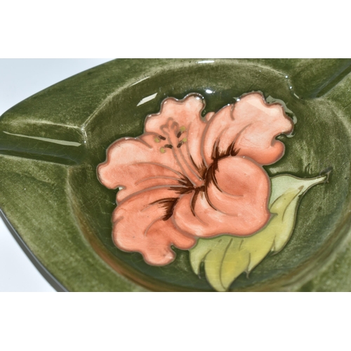 360 - A MOORCROFT POTTERY 'HIBISCUS' PATTERN TRIANGULAR ASHTRAY, tube lined with hibiscus flowers on a gre... 