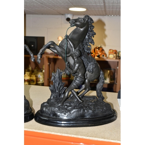 412 - A PAIR OF SPELTER MARLY HORSES, painted black, surmounting a wooden plinth, indistinct signature to ... 