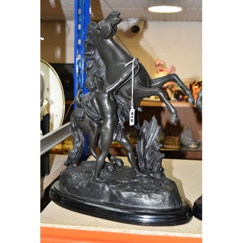 412 - A PAIR OF SPELTER MARLY HORSES, painted black, surmounting a wooden plinth, indistinct signature to ... 