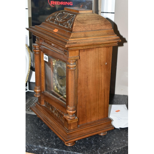 434 - AN EARLY 20TH CENTURY WALNUT CASED CHIMING BRACKET CLOCK, the caddy hood with foliate carved detail,... 