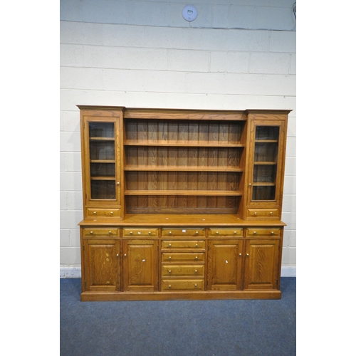 1275 - A LARGE SOLID OAK DRESSER, the reverse breakfront top fitted with an arrangement of shelving, two gl... 