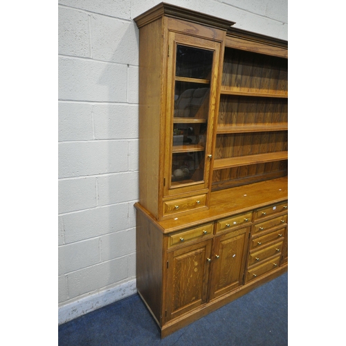 1275 - A LARGE SOLID OAK DRESSER, the reverse breakfront top fitted with an arrangement of shelving, two gl... 