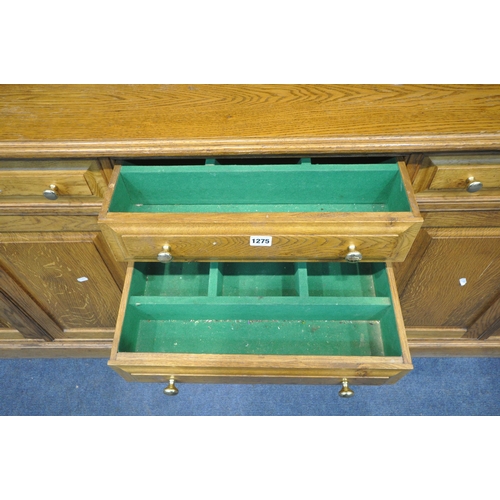 1275 - A LARGE SOLID OAK DRESSER, the reverse breakfront top fitted with an arrangement of shelving, two gl... 