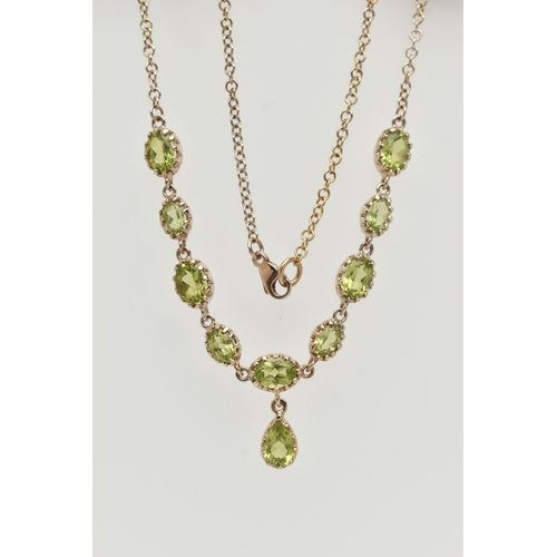 50 - A YELLOW METAL PERIDOT NECKLACE, designed as a row of nine oval cut peridots, each in a claw setting... 