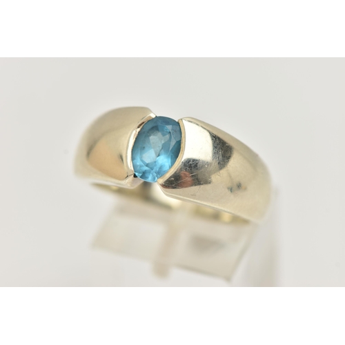 6 - A 9CT GOLD TOPAZ RING, oval cut blue topaz half bezel set, set in a wide tapered white gold band, ap... 