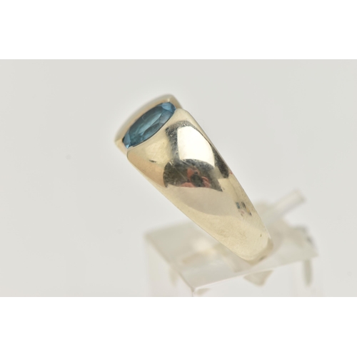 6 - A 9CT GOLD TOPAZ RING, oval cut blue topaz half bezel set, set in a wide tapered white gold band, ap... 