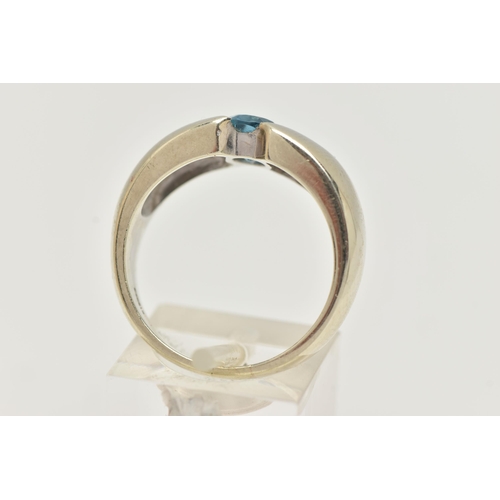 6 - A 9CT GOLD TOPAZ RING, oval cut blue topaz half bezel set, set in a wide tapered white gold band, ap... 