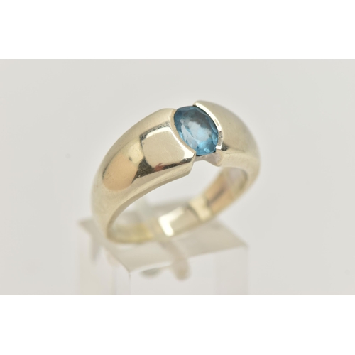 6 - A 9CT GOLD TOPAZ RING, oval cut blue topaz half bezel set, set in a wide tapered white gold band, ap... 