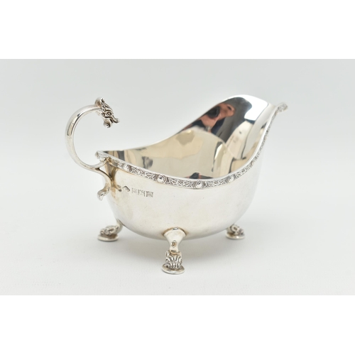 108 - AN ELIZABETH II SILVER SAUCE BOAT, polished design with Celtic pattern to the rim, raised on three d... 