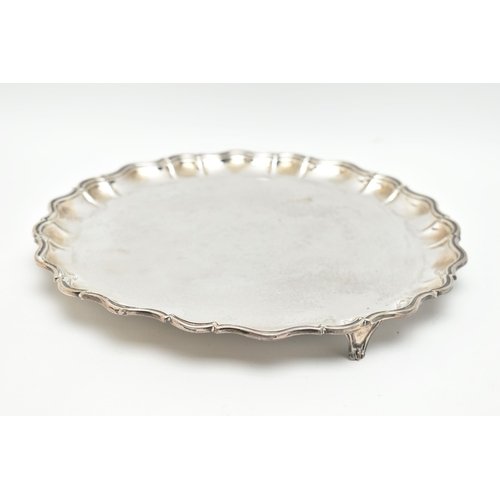 109 - AN EDWARDIAN SILVER SALVER, polished round wavy form, raised on three scroll feet, hallmarked 'James... 