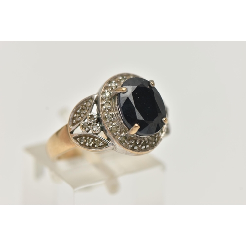 143 - A 9CT GOLD SAPPHIRE AND DIAMOND RING, principal oval cut sapphire prong set with a halo of single cu... 