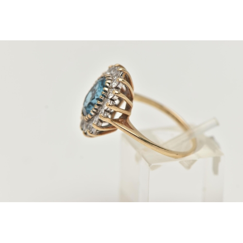 144 - A 9CT GOLD CLUSTER RING, centring on an oval cut blue topaz, in a surround of colourless cubic zirco... 