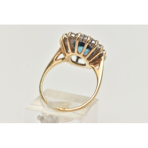 144 - A 9CT GOLD CLUSTER RING, centring on an oval cut blue topaz, in a surround of colourless cubic zirco... 