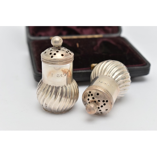 96 - A CASED PAIR OF LATE VICTORIAN SILVER PEPPERETTES, baluster swirl form, pierced covers with ball fin... 