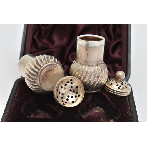 96 - A CASED PAIR OF LATE VICTORIAN SILVER PEPPERETTES, baluster swirl form, pierced covers with ball fin... 