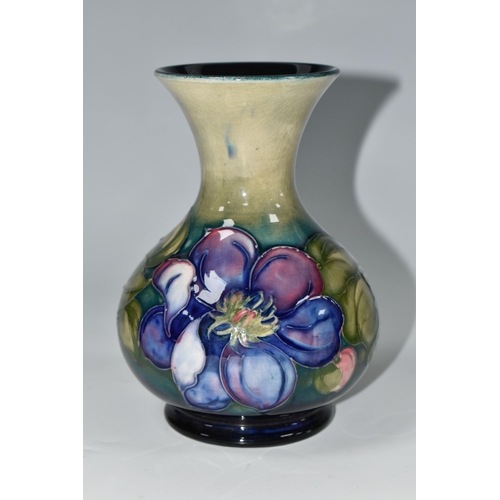 352 - A MOORCROFT POTTERY CLEMATIS VASE, the flared necked vase in 'Clematis' pattern on a graduated green... 