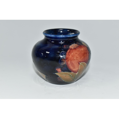 476 - A MOORCROFT POTTERY POMEGRANATE VASE, of squat form, tube lined in Pomegranate pattern on a deep blu... 