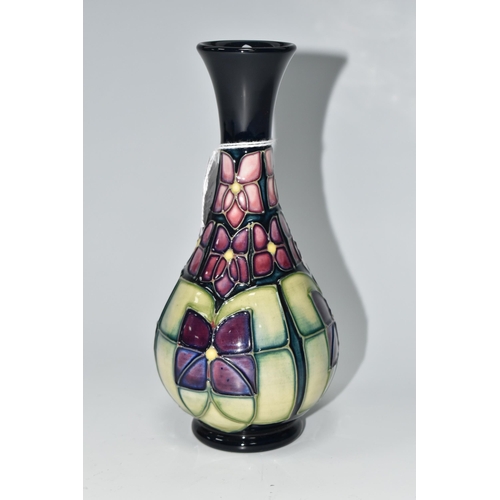 489 - A MOORCROFT POTTERY 'VIOLET' PATTERN BUD VASE, tube lined with stylised purple violets on a dark blu... 