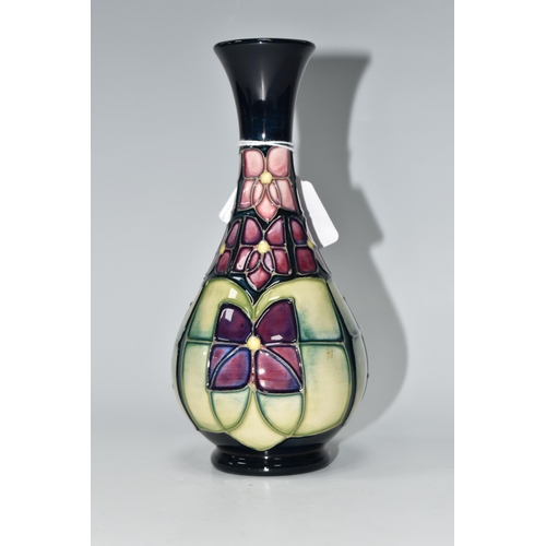 489 - A MOORCROFT POTTERY 'VIOLET' PATTERN BUD VASE, tube lined with stylised purple violets on a dark blu... 