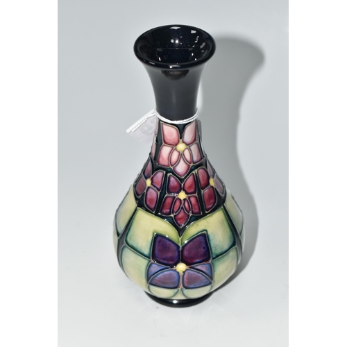 489 - A MOORCROFT POTTERY 'VIOLET' PATTERN BUD VASE, tube lined with stylised purple violets on a dark blu... 