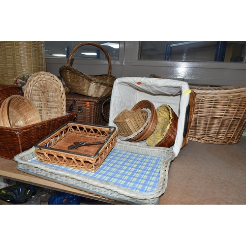 562 - A LARGE QUANTITY OF WICKER BASKETS, comprising linen baskets, serving tray, letter rack, flower bask... 