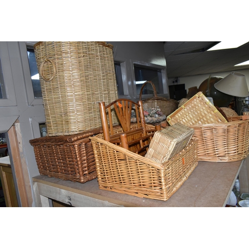 562 - A LARGE QUANTITY OF WICKER BASKETS, comprising linen baskets, serving tray, letter rack, flower bask... 