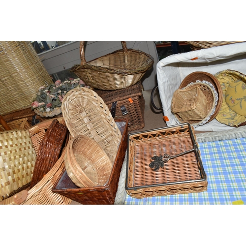 562 - A LARGE QUANTITY OF WICKER BASKETS, comprising linen baskets, serving tray, letter rack, flower bask... 