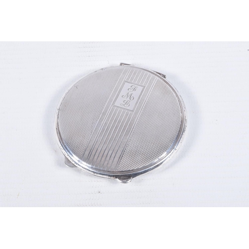 105 - A SILVER COMPACT, of circular outline with engine turned decoration and central banded detail with e... 