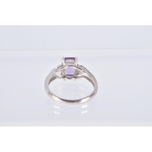 18 - A 9CT WHITE GOLD AMETHYST AND SPINEL RING, set with a rectangular cut amethyst, four claw set, flank... 