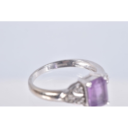 18 - A 9CT WHITE GOLD AMETHYST AND SPINEL RING, set with a rectangular cut amethyst, four claw set, flank... 