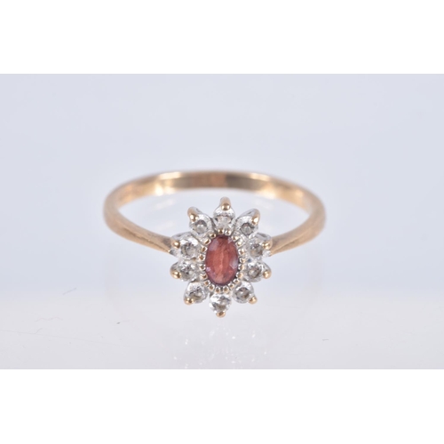 20 - TWO YELLOW METAL GEM SET RINGS, the first an oval cluster set with an oval cut garnet and colourless... 