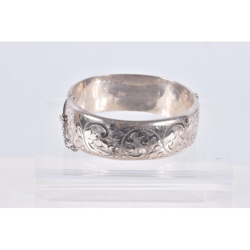 29 - TWO ELIZABETH II HINGED SILVER BANGLES, both with foliate engraved scrolls to one half, Birmingham 1... 