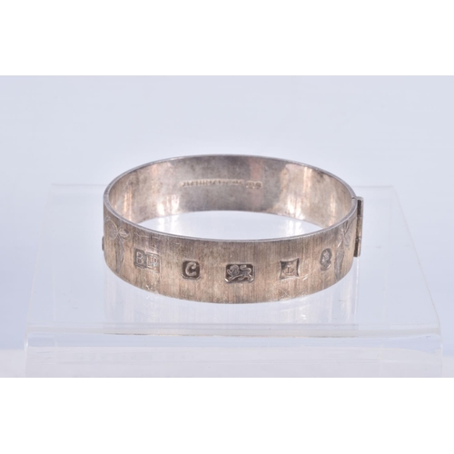 61 - TWO SILVER HINGED BANGLES AND A WHITE METAL CUFF BRACELET, the first a flat hinged bangle with folia... 