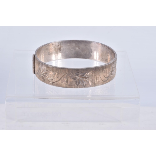 61 - TWO SILVER HINGED BANGLES AND A WHITE METAL CUFF BRACELET, the first a flat hinged bangle with folia... 