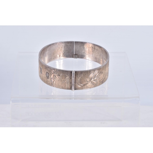 61 - TWO SILVER HINGED BANGLES AND A WHITE METAL CUFF BRACELET, the first a flat hinged bangle with folia... 