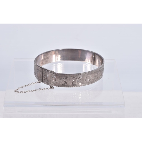 61 - TWO SILVER HINGED BANGLES AND A WHITE METAL CUFF BRACELET, the first a flat hinged bangle with folia... 