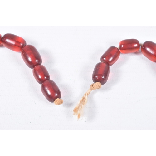 70 - A SINGLE STRAND OF GRADUATED RED PLASTIC BEADS, twenty four oval red beads, largest measuring 29.1mm... 