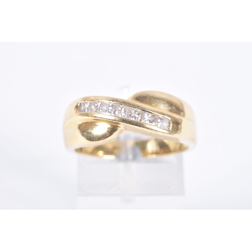 76 - AN 18CT GOLD DIAMOND SET RING, seven princess cut diamonds channel set in yellow gold, cross over mo... 