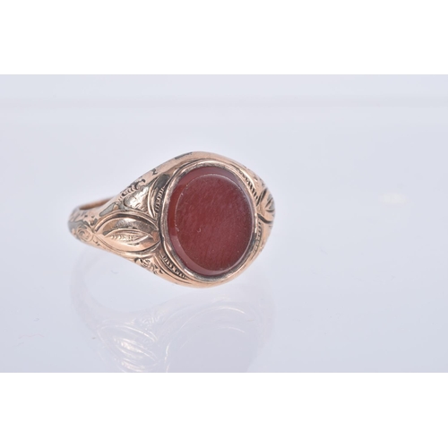 89 - A GENTS SIGNET RING, of an oval form, set with an oval carnelian panel, collet set to the textured s... 