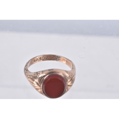 89 - A GENTS SIGNET RING, of an oval form, set with an oval carnelian panel, collet set to the textured s... 