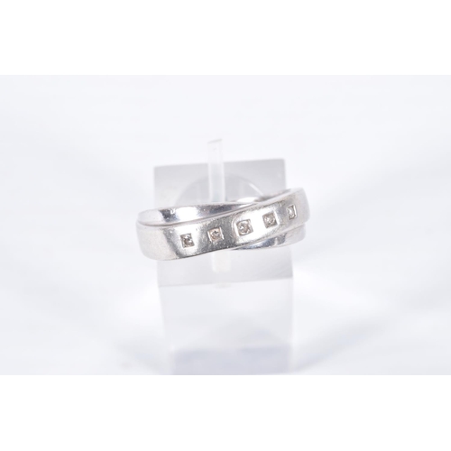 9 - A 9CT WHITE GOLD DIAMOND RING, crossed band design set with a row of five small round brilliant cut ... 