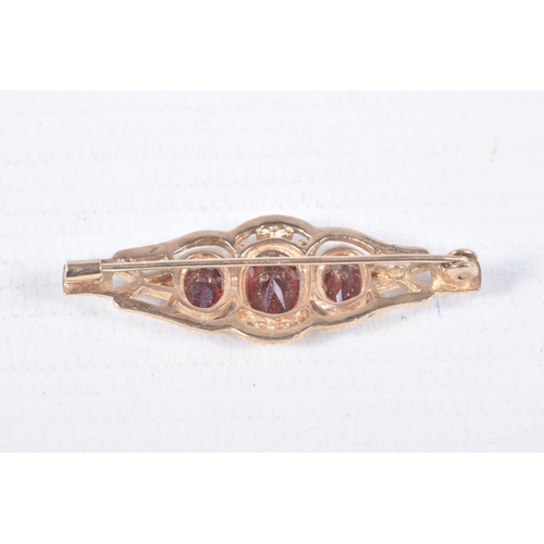 97 - A 9CT GOLD RING AND YELLOW METAL BROOCH, an oval cut garnet, prong set in yellow gold leading on to ... 