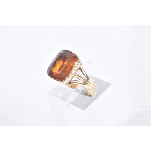 99 - A MID VICTORIAN PASTE RING, the rectangular orange paste in a closed back setting, to the trifurcate... 