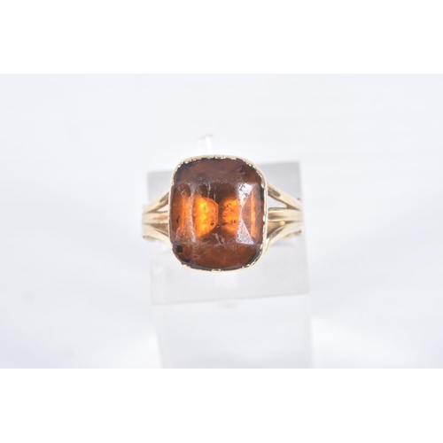 99 - A MID VICTORIAN PASTE RING, the rectangular orange paste in a closed back setting, to the trifurcate... 