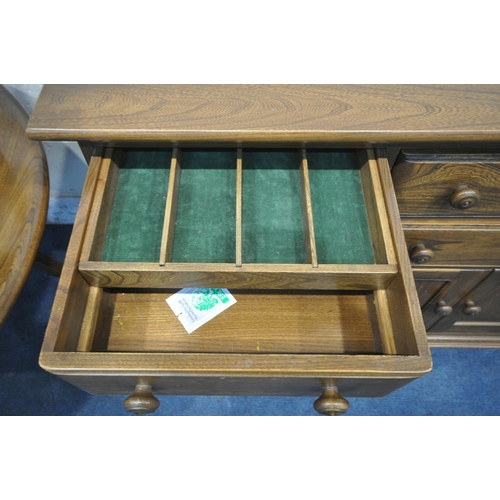 1229 - AN ERCOL ELM AND BEECH CANTERBURY SIDEBOARD, fitted with an arrangement of four drawers and doors, o... 