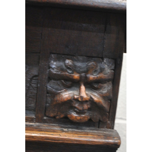 1310 - A GEORGIAN AND LATER OAK COFFER, with a hinged lid, twin mask carving, geometric and foliate panels,... 